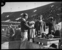 E. Manchester Boddy awards football trophy to Oliver Anderson at the Coliseum, Los Angeles, 1930s