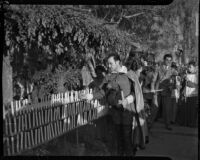 Spanish baritone Felipe Delgado lights candles while wearing a costume, Los Angeles, 1930s