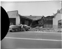 Wreckage after an automobile swerved off the road and crashed into the front of a building, Los Angeles, 1940s