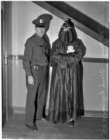 Police officer stands with R.F. McGarry, member of the Black Legion secret society, Los Angeles, 1936