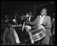 African American boy playing drum set at 1941 Children's Christmas party at May Co. department store in Los Angeles, Calif