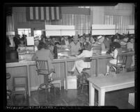 Three women manning information desk at Los Angeles area employment office, Los Angeles, circa 1944