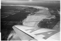 Aerial view of flood water moving down a river in North Hollywood after a major flood, Los Angeles, 1938