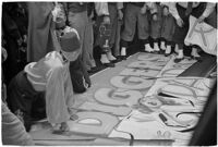 Member of the Mystic Shrine attending to a sign for the Durbar festival, Los Angeles, 1937