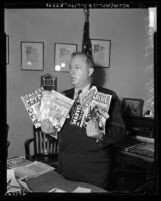 City councilman Ernest Debs holding horror comic books that were purchased in his district in Los Angeles, 1954