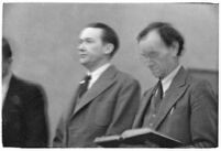 Murder suspect Robert S. James standing between two unidentified men in court, Los Angeles, 1936