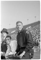 USC track athlete sitting with others on the sidelines at a meet, Los Angeles, 1937