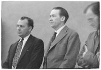 Murder suspect Robert S. James standing between two unidentified men in court, Los Angeles, 1936