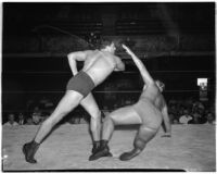 Heavyweight wrestler Vincent López as his opponent falls to the mat during a wrestling match, Los Angeles, 1930s