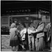 Woman and man talking to truant teenagers standing outside a jewelry store, Los Angeles, March 1946