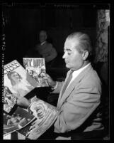 Councilman Ed J. Davenport displaying nude comic books in Los Angeles, 1948