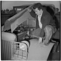 Manuel Sanchez looks at a truck engine during the War Assets Administration's surplus truck and trailer sale, Port Hueneme, May 1946