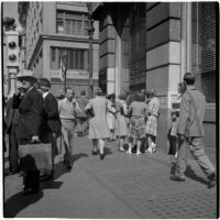 Woman talking to a group of truant girls in the crowd in downtown Los Angeles, March 1946