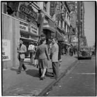 Woman talking to truant boys outside a movie theater downtown, Los Angeles, March 1946