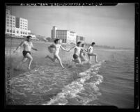 Five bathers running into ocean at Santa Monica Beach, circa 1947