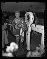 Jockey covered in mud standing on scale at Santa Anita Race Track in Arcadia, Calif., 1948