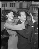 Magician Charles Hoffman is blindfolded by actress Marsha Hunt, before his automobile race down Hollywood Blvd. against a fellow illusionist