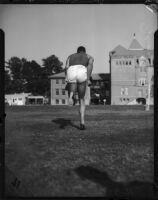 Jesse Owens photographed from the back while running, Los Angeles, 1930s