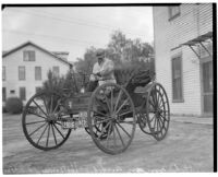 J.H. Ozmun pictured in his Model 3 Holsman "Highwheeler" car after a cross-country trip, February 16, 1936