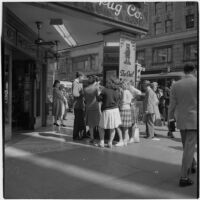 Woman talking to truant teenagers standing outside a drugstore, Los Angeles, March 1946