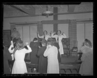 Two women leading prayers at Angelus Temple after news of Aimee Semple McPherson's death