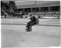 Spectator reads the paper at the Santa Anita racetrack, February 22, 1937