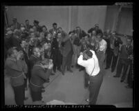 Two men instructing a group of male civilians on how to wear a gas mask in 1942, Los Angeles, Calif