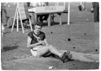 USC track athlete landing in sand after a jump, Los Angeles, 1937