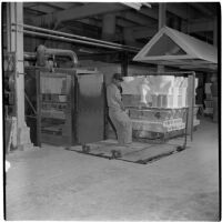 Employee pulls a cart of ceramic toilets at the Universal Vitreous China Factory, Mentone, circa 1948