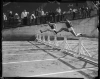 Jesse Owens competes in a hurdle race against an unidentified member of the USC track team, Los Angeles, 1935