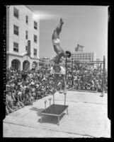 Mr. Muscles contestant performing acrobatic move as crowd watches at Muscle Beach in Santa Monica, Calif., 1948