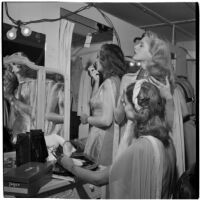 Charlotte Lander and two other models prepare for a fashion show in their dressing room, Los Angeles, September 1946