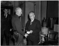 Deputy Sheriff J. A. Dixon and Attorney Ross F. Wilkins shaking hands after clearing up a misunderstanding that led to a fist fight between the two men at a jury selection session, Los Angeles, 1940