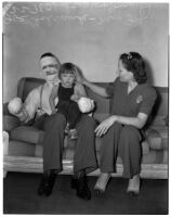 Joe Schrank, with his hands and face completed covered in bandages, sits with his wife and their young daughter Joan, Los Angeles