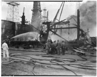 Oil field workers watch as fire fighters attempt to control a blaze at the Santa Fe Springs oil field, Santa Fe Springs, July 29, 1937