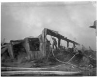 Firefighter walks through the ruins of a fire that occurred at Dura Steel Products Co., Los Angeles, 1940