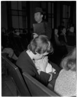 Miss Leo C. Moore sitting in a crowd holding her young child, Los Angeles