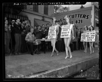 Earl Carroll's Vanities, chorus girls in costumes and wearing placards picketing Los Angeles Musicians Union Hall, 1938