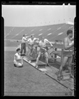 Four male Los Angeles police applicants being evaluated during physical fitness tests in 1946