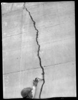 Man pointing at crack in Saint Francis Dam after its collapse, San Francisquito Canyon, 1928