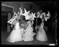 Three women in gowns and headdresses at Las Floristas Headdress Ball at the Biltmore Hotel in Los Angeles, Calif., 1952