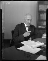 Judge Thomas L. Ambrose, seated in his study