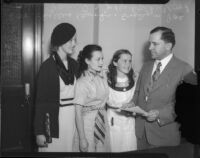 Actresses Evelyn Poe, Helen Parrish, and Phyllis Brooks pose with Judge Parker Wood after their film contracts are approved, Los Angeles, 1935