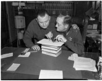 Deputy Sheriff J. J. Stearns and jailer Clem Peoples examining a handcuff key that was made out a spoon by bank robber Joseph Paul Cretzer, Los Angeles, 1940