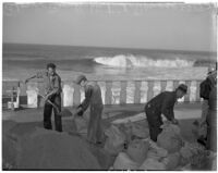 Men fill sandbags at Redondo Beach to protect against heavy seas, January 1940