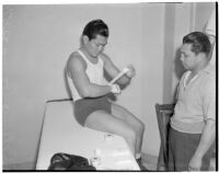 Ceferino Garcia, champion boxer from the Philippines, wrapping his hand with a bandage, Los Angeles, circa 1938