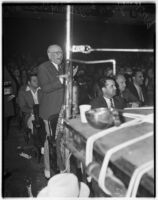 Spectators at a wrestling match, one man stands clapping and yelling, Los Angeles