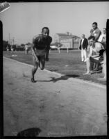 Jesse Owens sprints in front of a few spectators, Los Angeles, 1930s