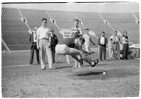 Track athlete completing a jump at a meet between UCLA and USC, Los Angeles, 1937