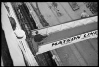 Passengers on the S.S. Mariposa looking down at a man on a walkway, Los Angeles